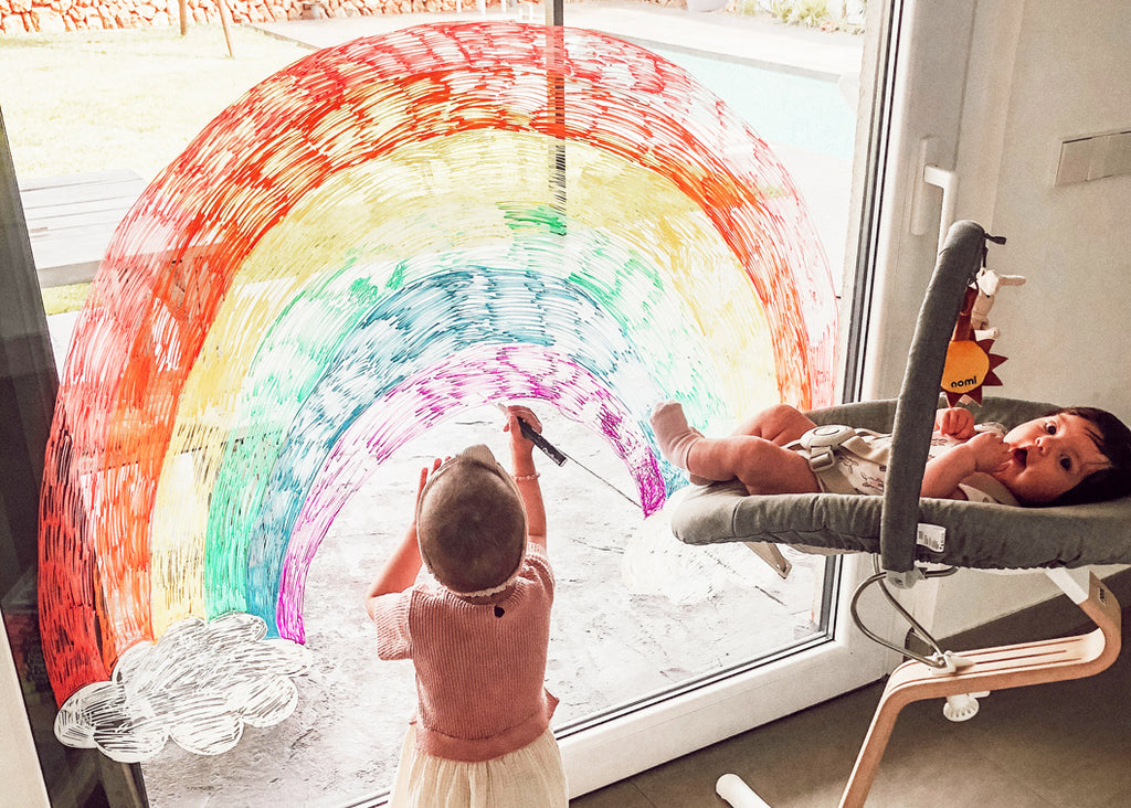 Child Drawing Rainbow on Window