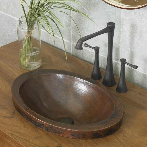 hammered oval copper sink in a bathroom