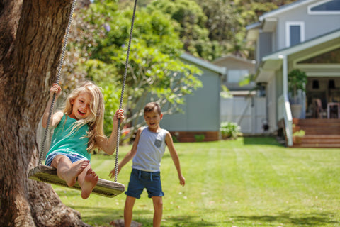 Children on Rope Swing Hanging from Tree Outside