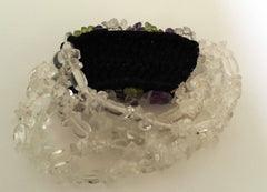 Stretchy bracelet of clear, purple, and green glass beads