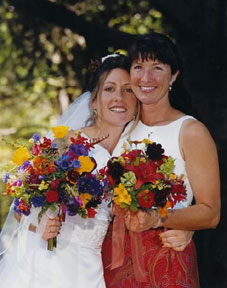 A bride and another woman holding multicolored posies - Renee's Garden