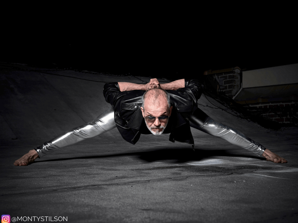 Older man in silver meggings doing splits stretching