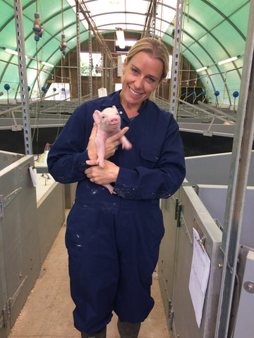 Sasha Conlan holding piglet at Wicks Manor Pork