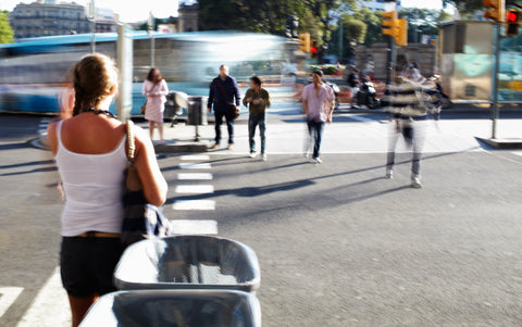 Woman crossing busy street with blurred pedestrians to represent fast pace