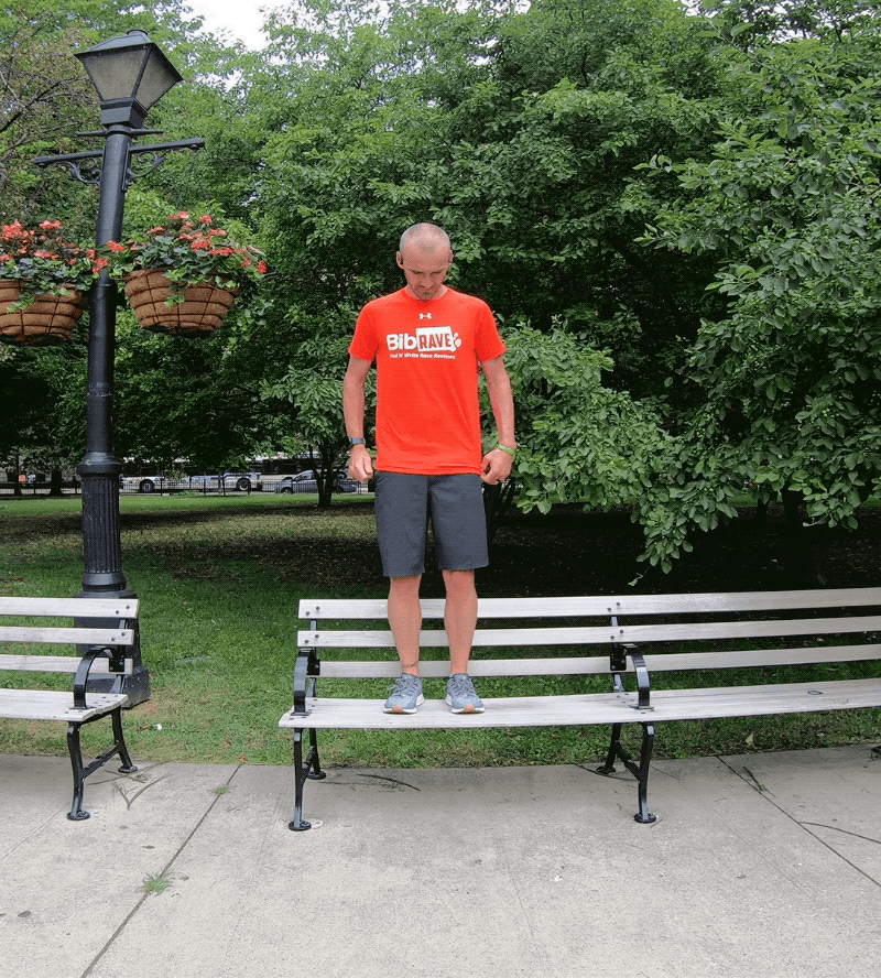 Man stepping off bench with one leg