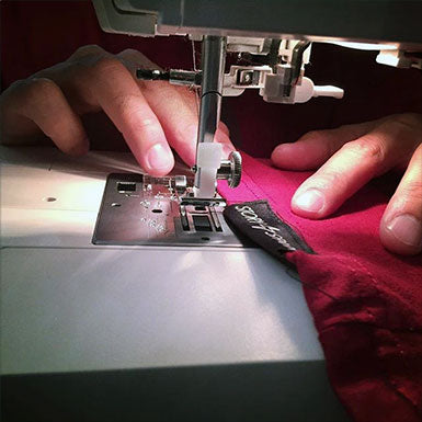 Sewing hem tags onto STORY SPARK techie graphic tees