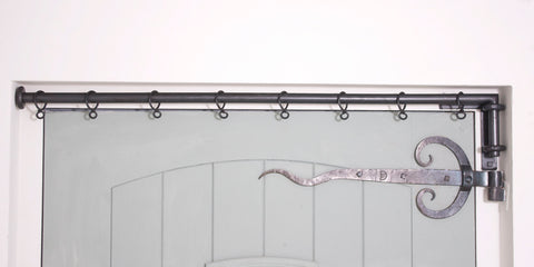 Wrought iron drapery arm fitted in door recess with L-shaped bracket