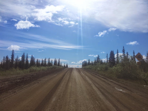 The muddy 'road' of the Dalton Highway, the skies clearing in between the endless downpours of rain