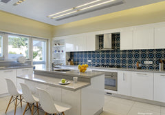 Sleek family kitchen with the bright blue, handmade, tiles as an eye catching splash back. 