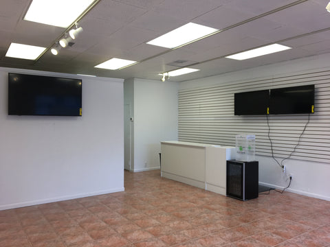 Inside of store with white walls and tv screens and counter top
