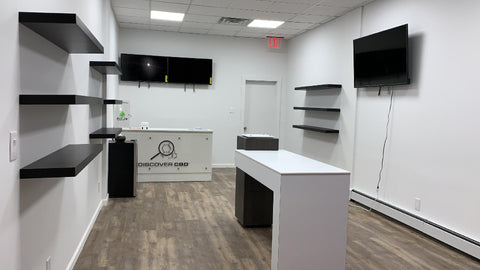 inside of store with shelves, tables, screens, white and black decor