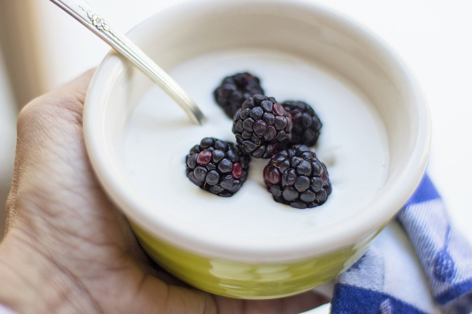 Greek yogurt with a spoon and blackberries.