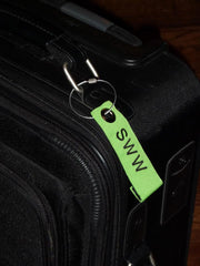 Personalized Neon Green Luggage Tag on Black Suitcase