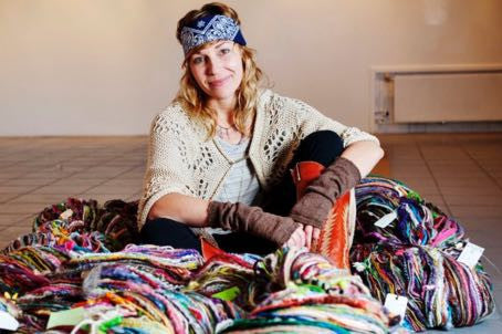 True Fiber Addict: Woman surrounded by colored yarn and wool