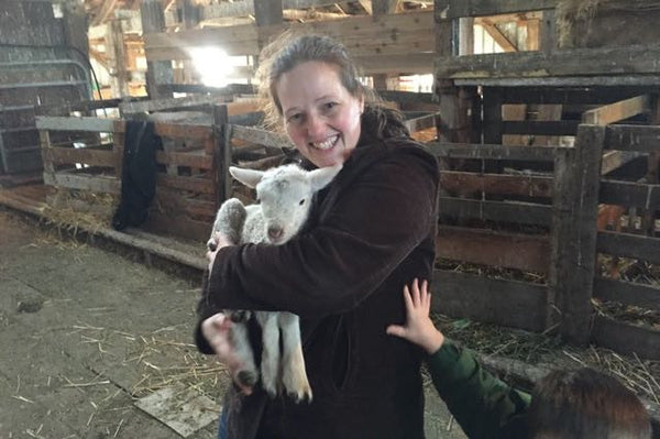 Mother holding baby lamb