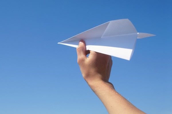 Paper airplane set against a blue sky