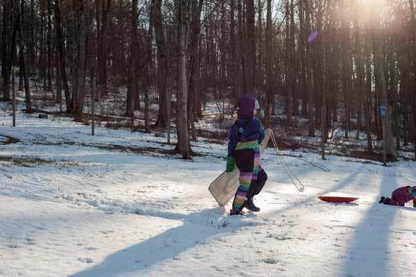 snow hill with child walking sled