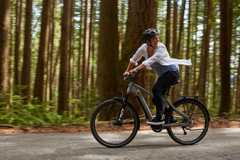 Woman laughing on her e-bike in the forest
