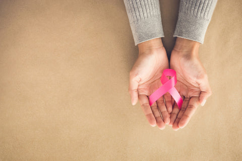 hands holding pink ribbon