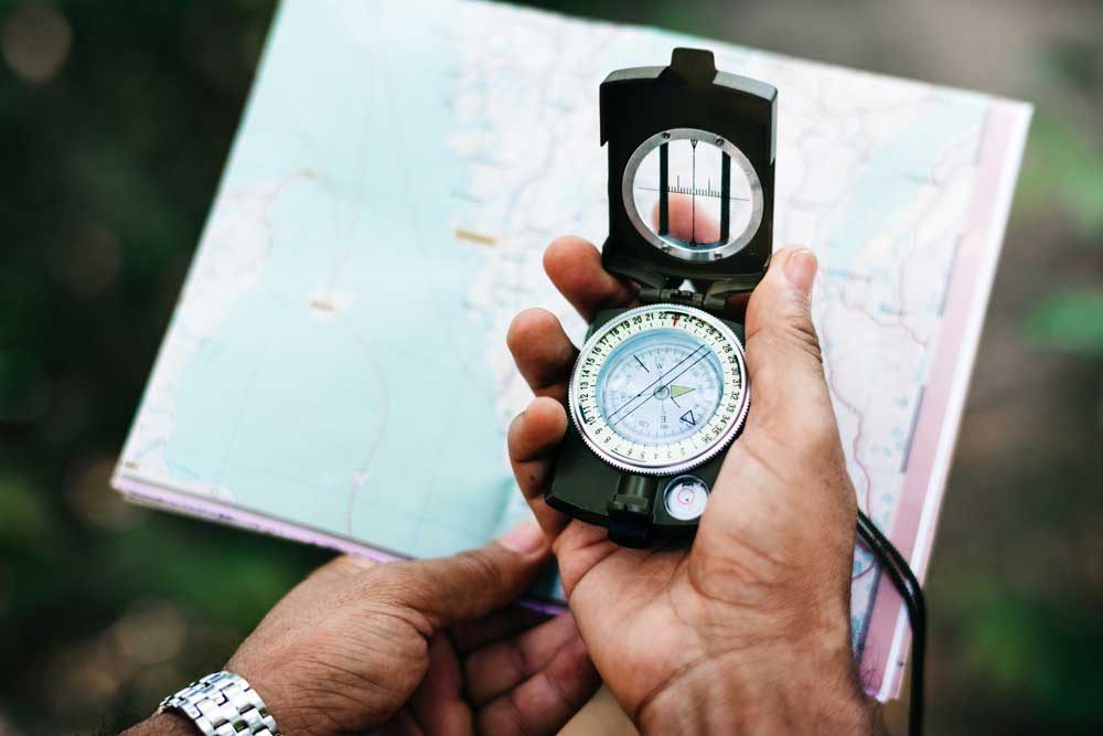 Hiker consulting map with compass.