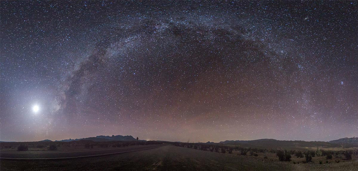 Starry night sky panorama: Captured amidst a desert road.