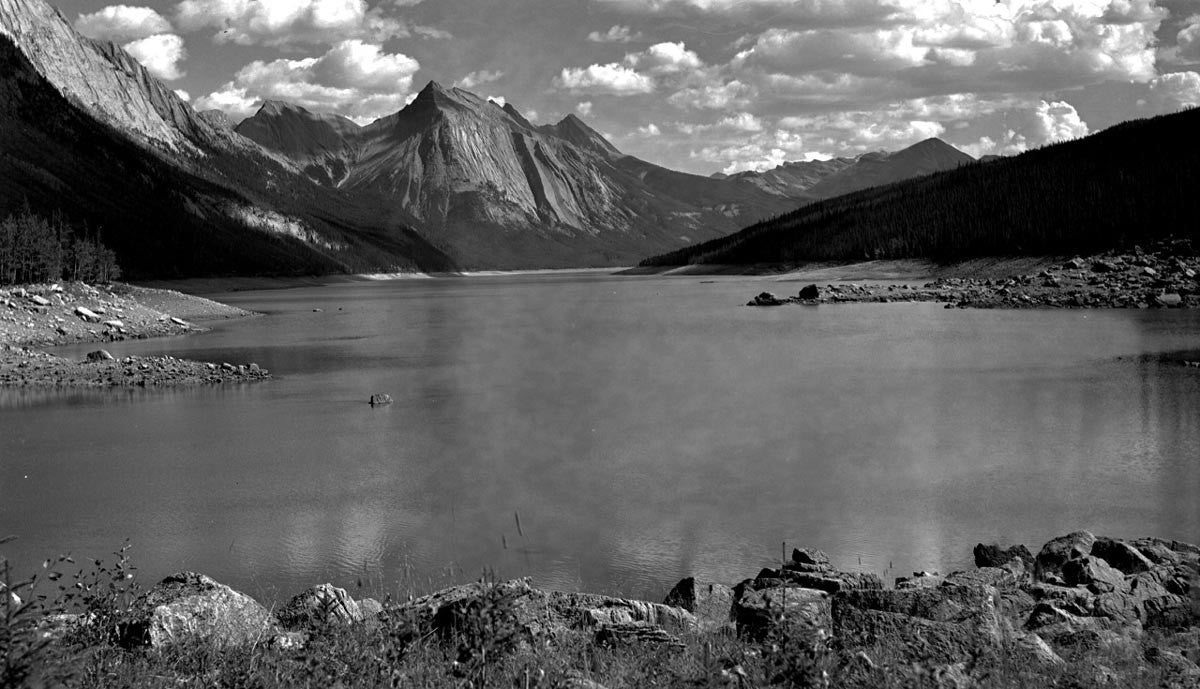 Scenic monochrome of a mountain lake surrounded by towering peaks.