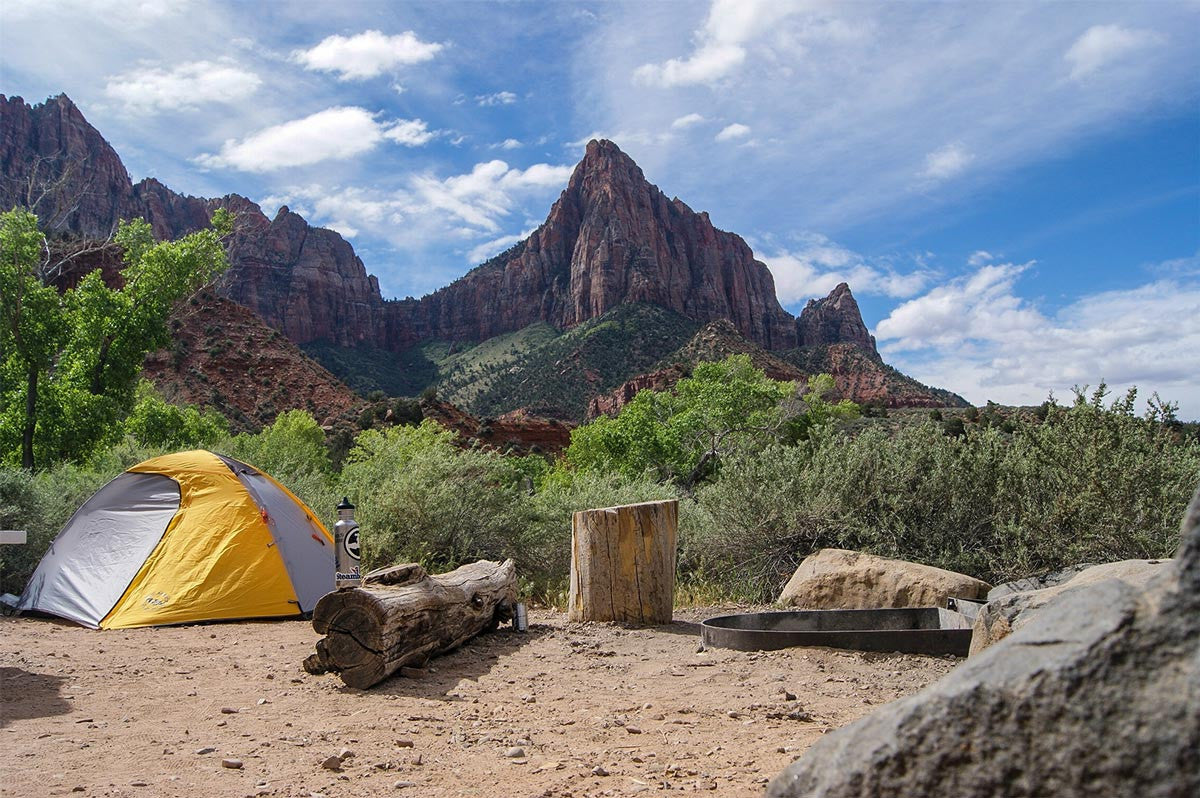 Campsite serenity: Tent with stunning red rock cliffs in the background.