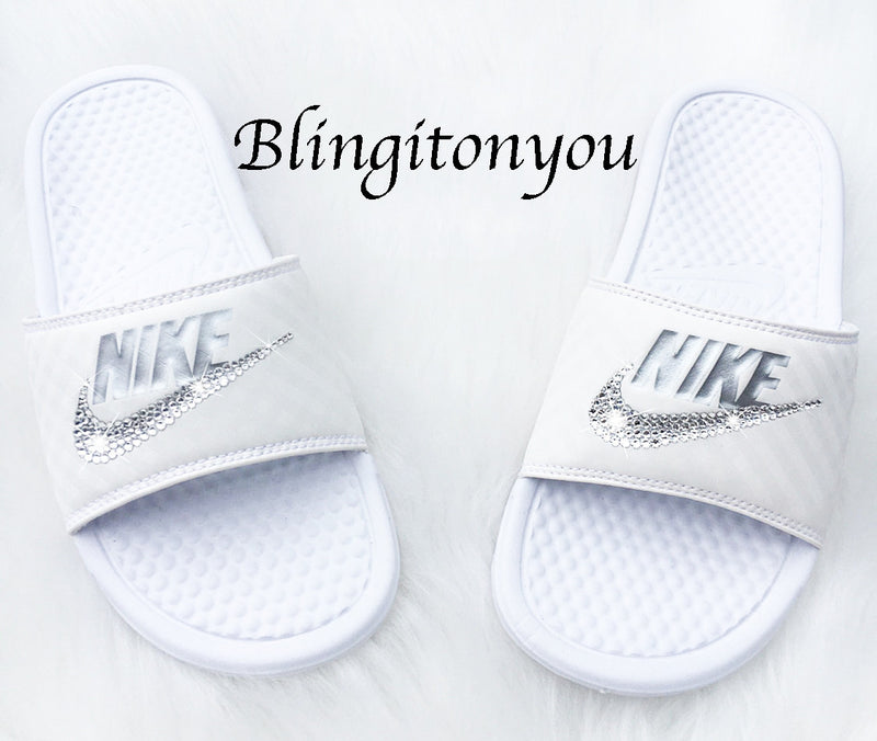 white and silver nike slides