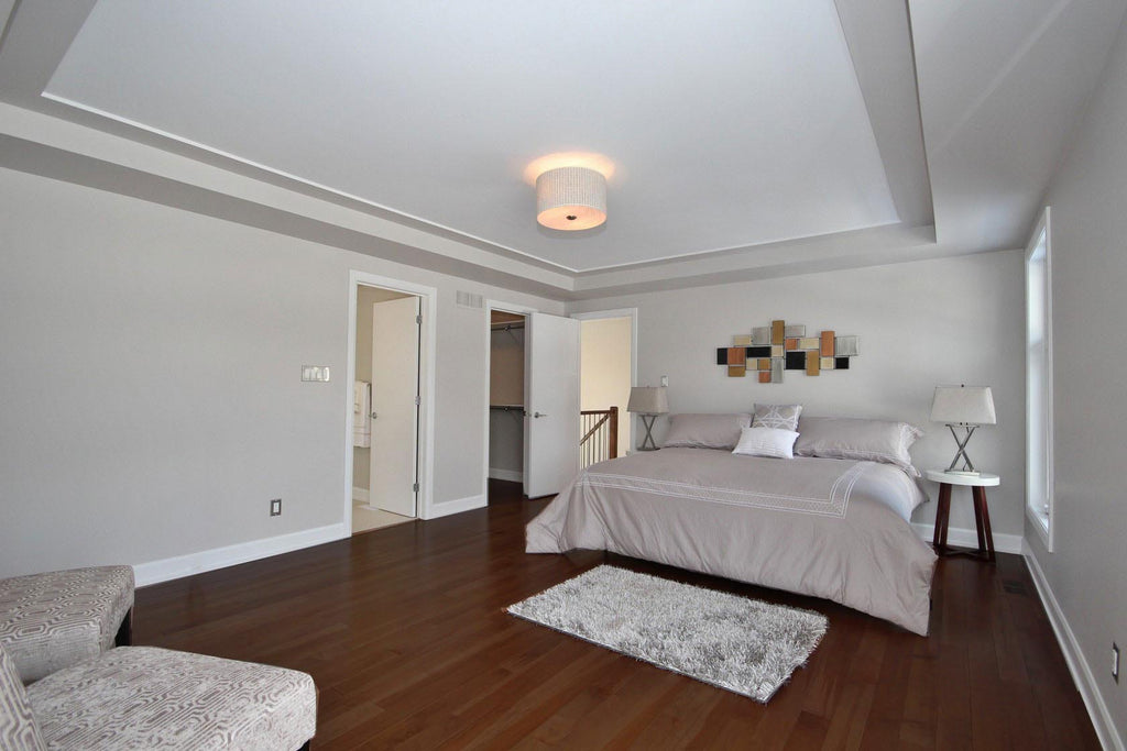 Modern bedroom with medium toned hardwood flooring