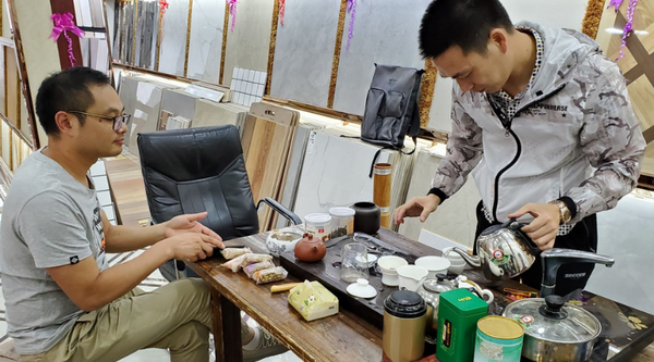 Mr. Tang and Mr. Chen. We were drinking tea at a tea table in the middle of a ceramic flooring showroom.