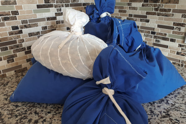 a pile of blue and white bags bulging with food