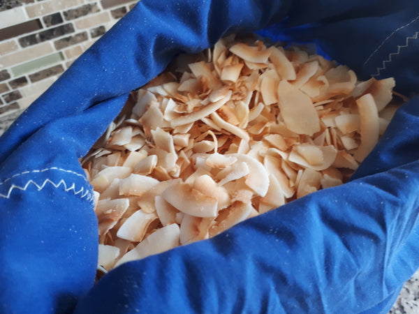 Blue cloth bag opened to show toasted coconut flakes