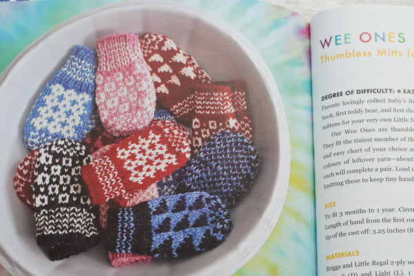 Bowl of colourful baby mittens featuring graphic patterns
