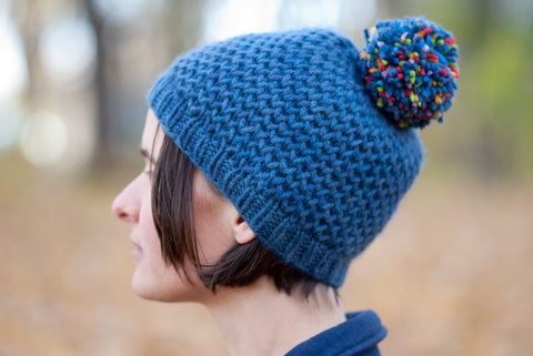 Hanabi blue hand-knit hat in honeycomb brioche pattern with a multicoloured pompom