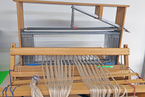 A table loom in the middle of the warping process