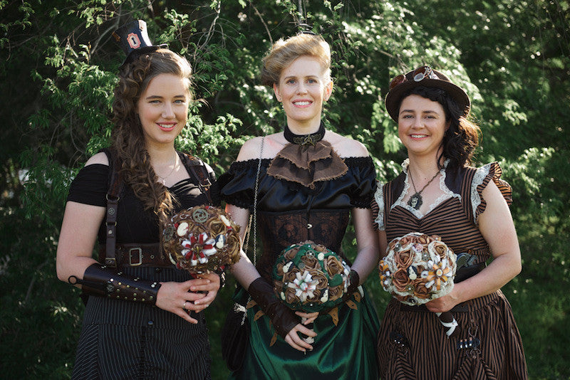 Bridesmaids outfitted by Gallery Serpentine and holding steampunk bouquets