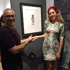 Erick and Monique Mantell in front of the drawings framed by Frames and Stretchers