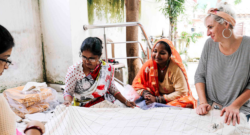 Anchal artisans quality controlling a piece hand stitched by a woman in Ajmer, India