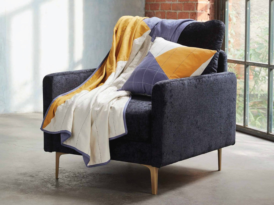 Anchal and Brooklinen collaboration throw quilt and pillow in a modern chair