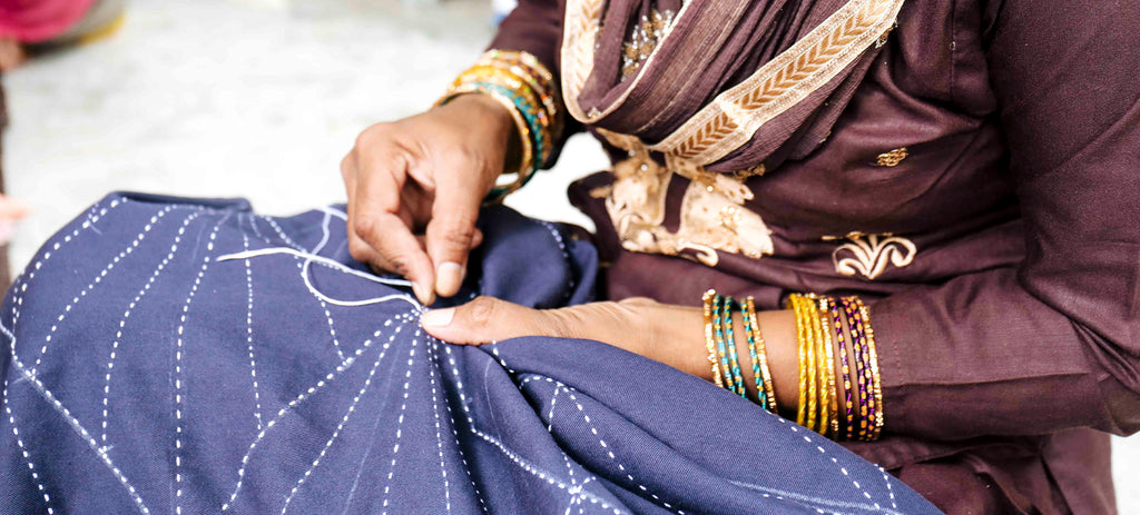 Artisan hand stitching fabric for the Anchal Array cocoon jacket