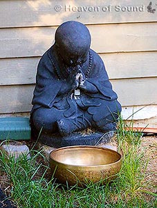 Praying monk with Tibetan singing bowl