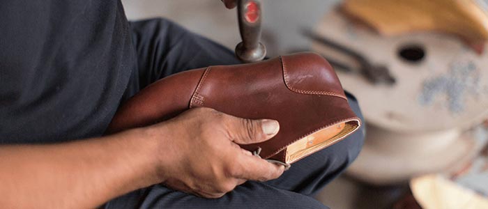Craftsman shaping the sole of a handmade leather shoe