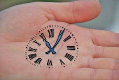clock ink stamped on open palm of left hand of an adult