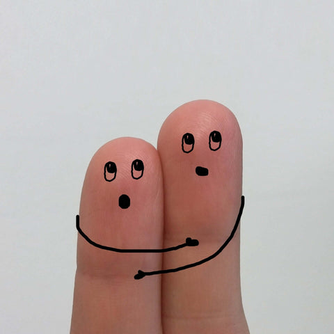 Two fingers with couple hugging drawn on them
