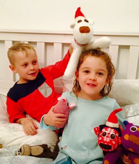 Two children playing with Christmas Red Rufus SockDogs