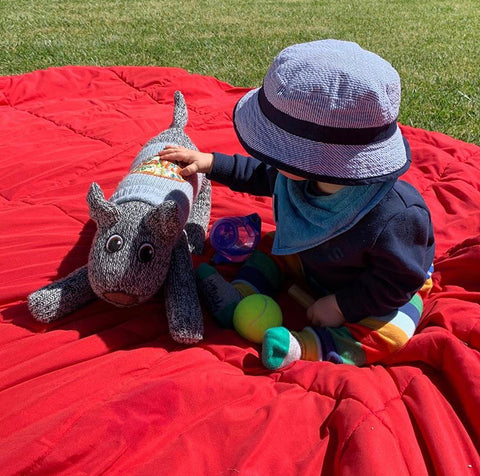 Baby stroking a Red Rufus SockDog