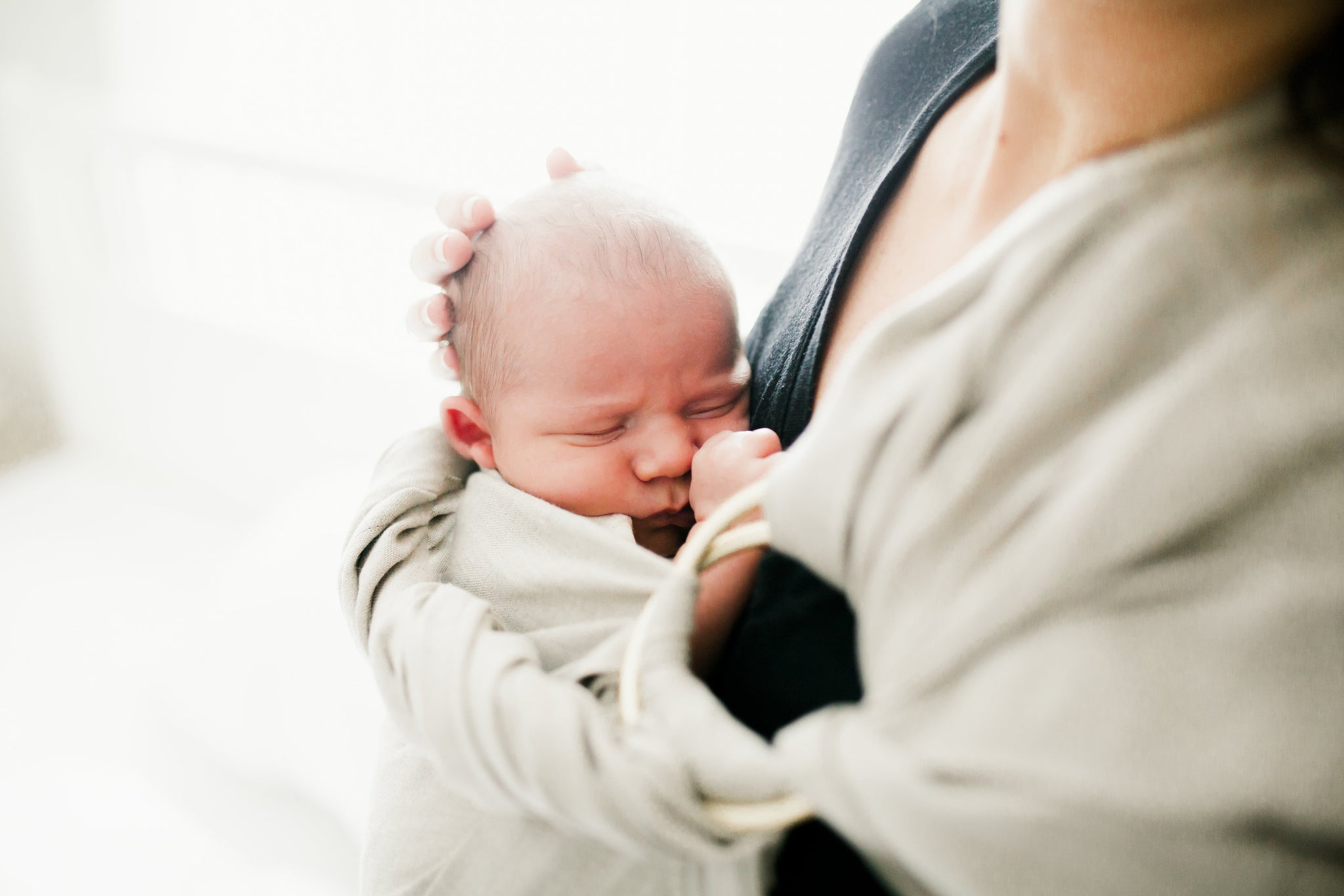 newborn baby in baby sling 