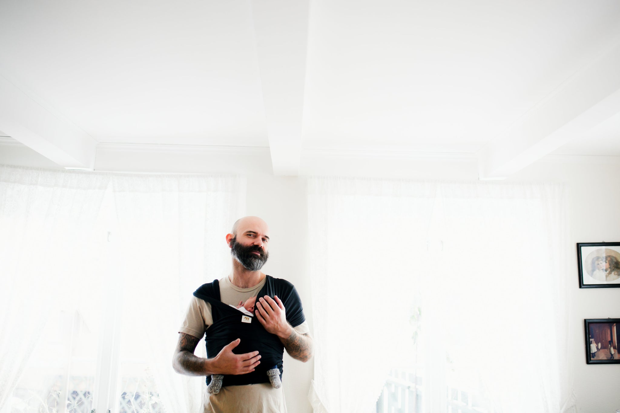 Father wearing new born baby in wrap sling 