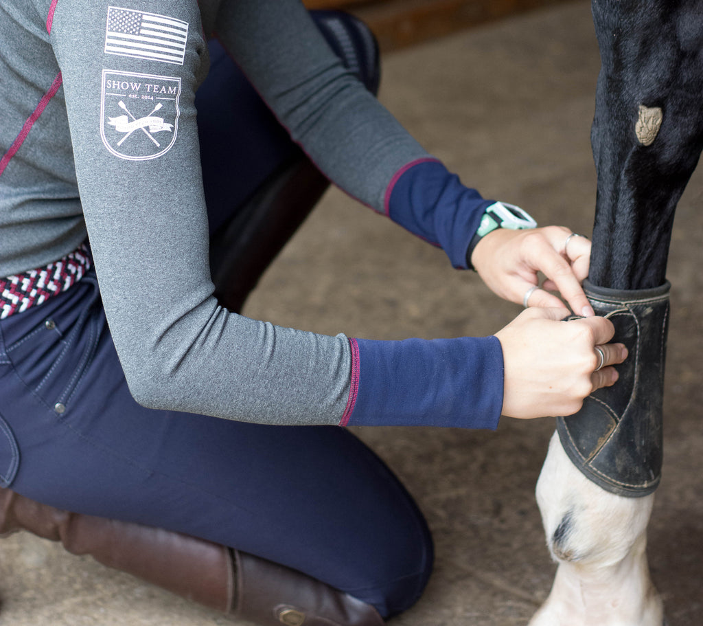 Rider putting on horse boot