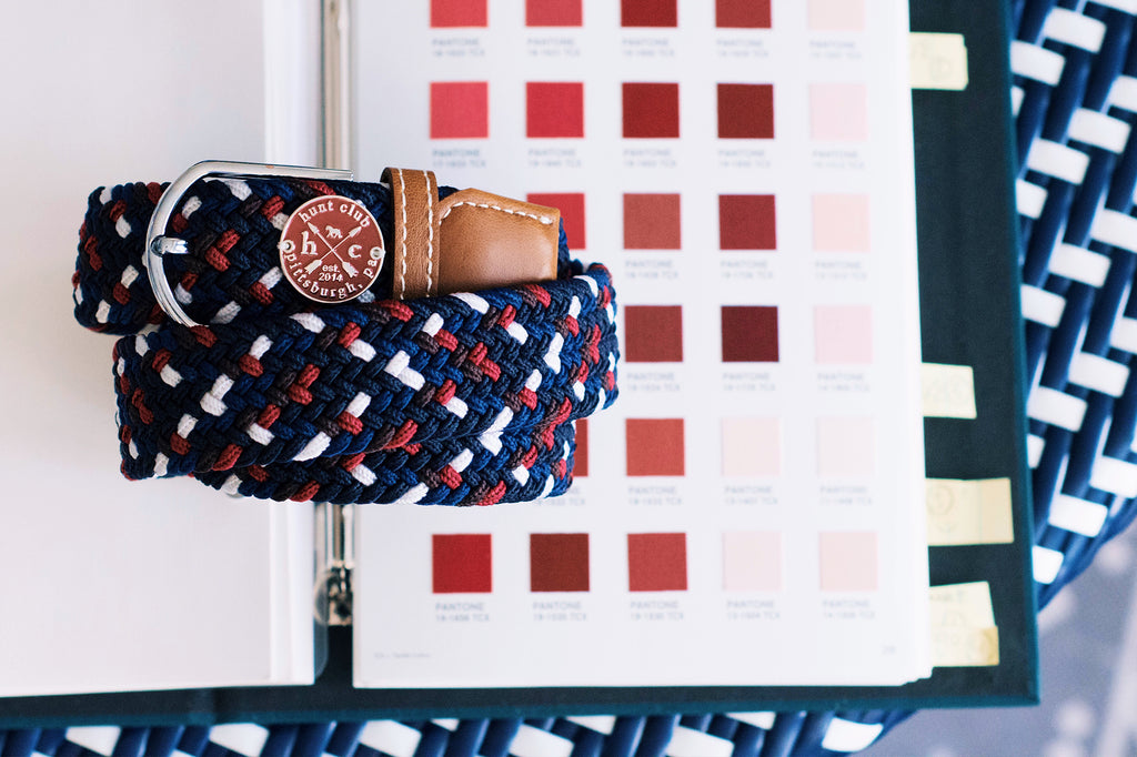A Hunt Club Derby Belt laid on top of matching Pantone color swatches. 